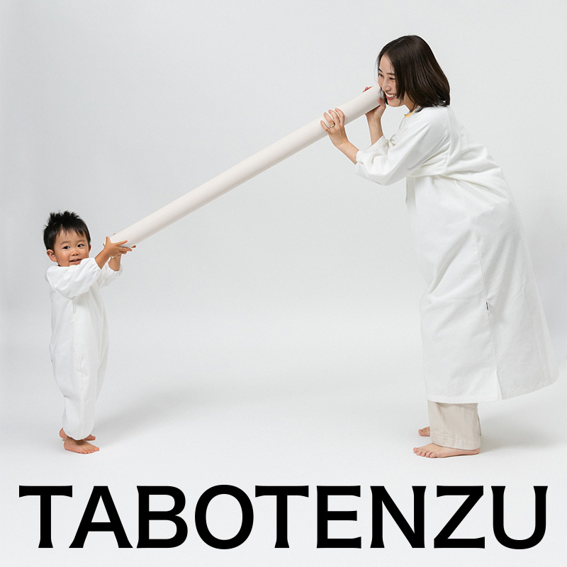 かぞくのおえかきウェアを着用した親子が長い筒を持って遊んでいる写真