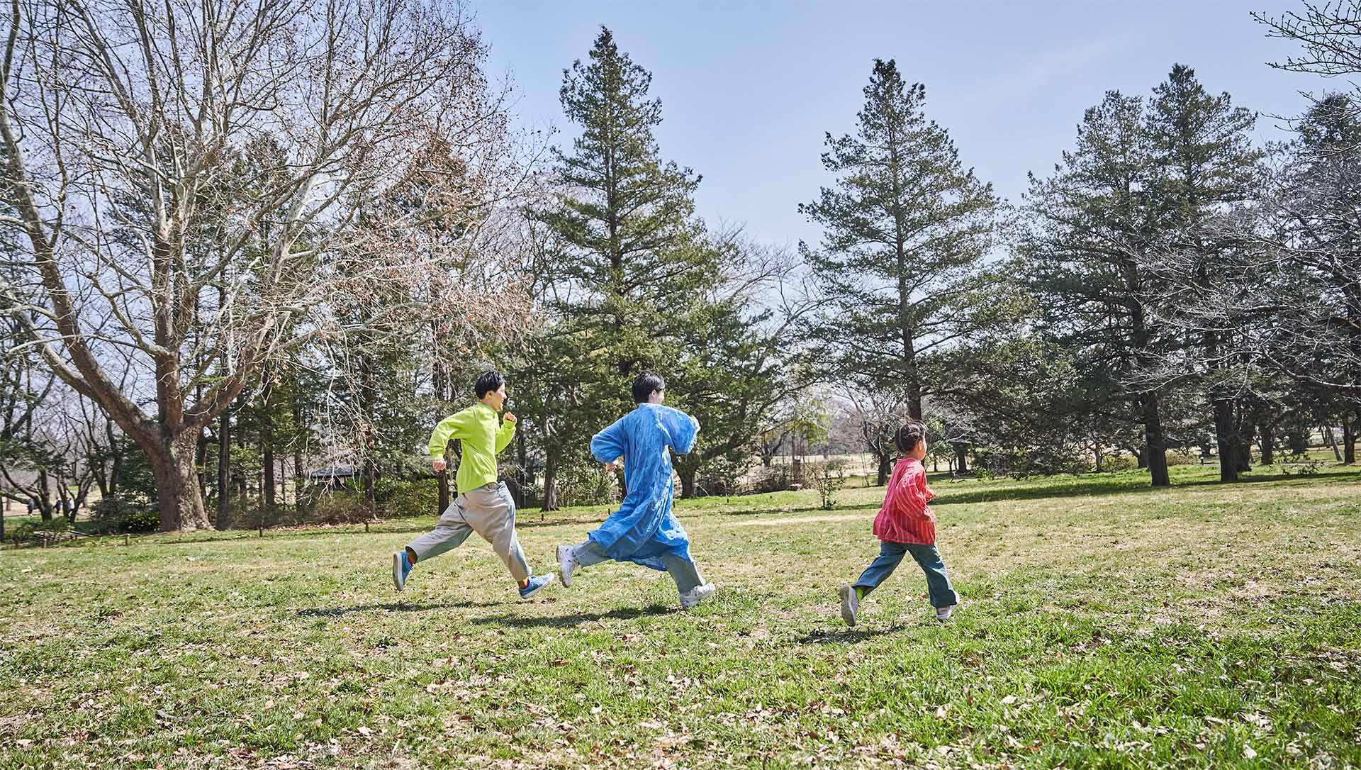 家族３人で芝生を走っている様子