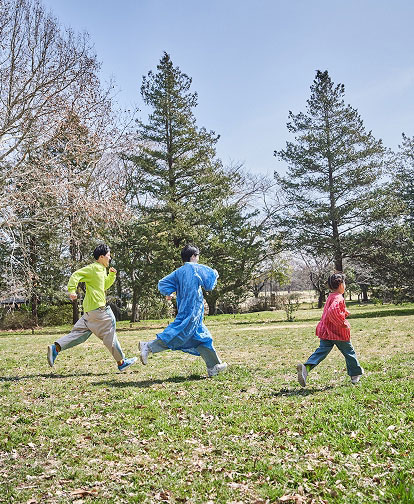 家族３人で芝生を走っている様子
