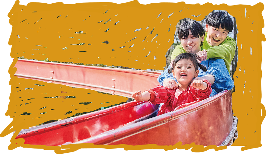 ３人家族が滑り台を滑っている写真